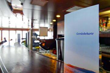 Detail view of Bar menu with counter and cozy maritime lounge or bar onboard classic cruiseship or...