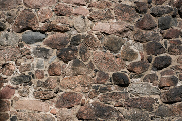 Old brown rough stone wall background. 