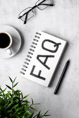 FAQ web communication concept. Text on notebook. top view