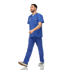 healthcare, profession and medicine concept - doctor or male nurse in blue uniform with stethoscope walking over white background
