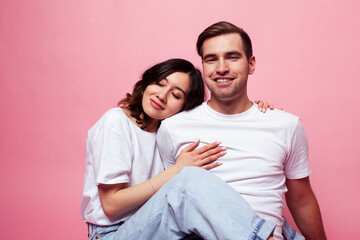 Fototapeta premium young cheerful caucasian couple together having fun on pink background, guy ang girl modern relationship, lifestyle people concept