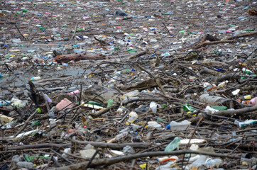 Plastic bags, bottles, garbage and trash dumped in river in nature. Water pollution. Rubbish and waste floating in contaminated lake. Ecological and environmental disaster. Ecology issue