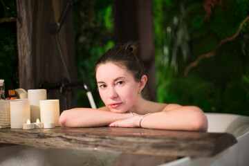 Obraz na płótnie Canvas Woman relaxing in bath with tropical plants. organic skin care