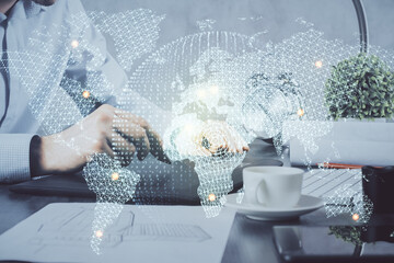 Double exposure of man's hands holding and using a phone and international business theme drawing.