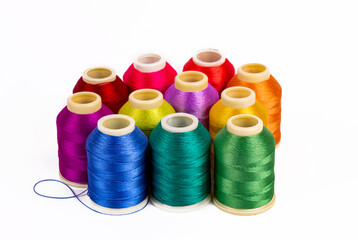 Colored thread coils on white background, sewing, place for text