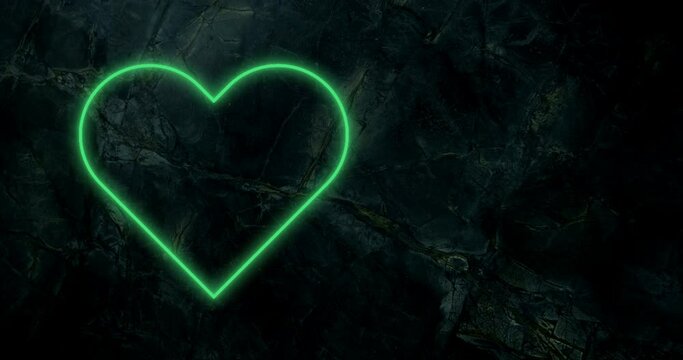 Animation of green neon heart flashing on dark wall