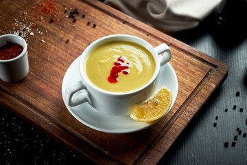 Oriental dish - a yellow lentil cream soup in white on a dark background piala