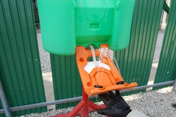 Workers are activating eye wash station for emergency use at construction site in a chemical factory.