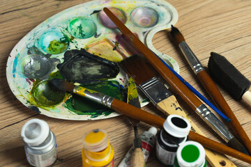 Paints and brushes on a palette. The artistic life of a creative person. Art studio at home