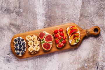 Homemade summer toast with cream cheese, nut butter and fruits and berries