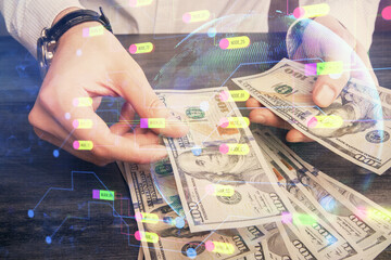 Double exposure of technology drawing hologram and us dollars bills and man hands. Data concept