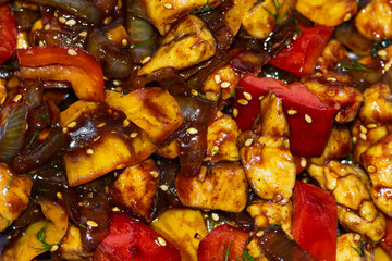 Braised chicken with onion, sweet pepper and sesame seeds in a dark sauce. 