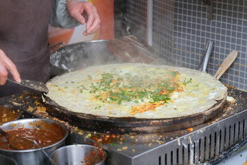 close up hand cooking Chinese pancake. Traditional street food in China