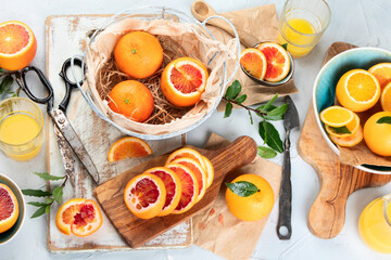 Oranges and juice in basket on light background