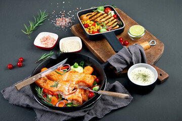 Homemade fresh salmon with starter and vegetables on dark background