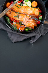Homemade fresh salmon with starter and vegetables on dark background