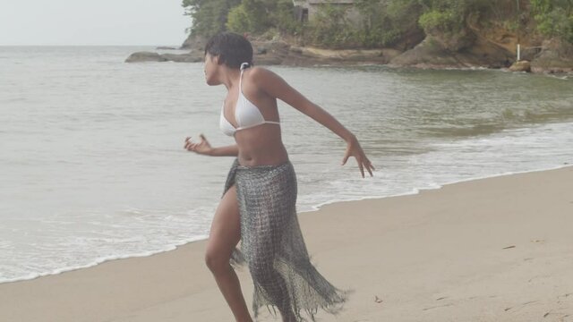 Epic dance moves from a young woman at the beach in a sexy bikini