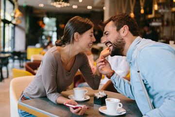 Young happy couple at a date in a coffee shop
