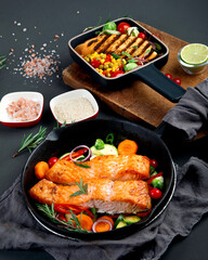 Homemade fresh salmon with starter and vegetables on dark background