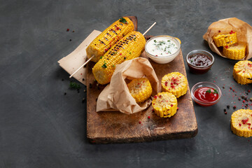 Grilled roasted sweet corn cobs with souces