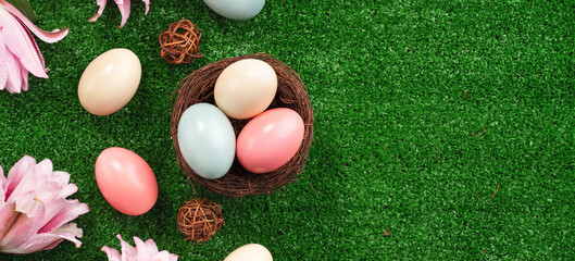 Fototapeta na wymiar Colorful Easter eggs in the nest on a lawn with pink Double Lily flower.