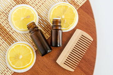 Two small bottles with essential lemon oil (extract, tincture, infusion, perfume) and wooden...