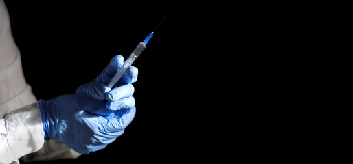 Doctor's hands in medical gloves hold a syringe with vaccine against omicron strain.  Close-up on...