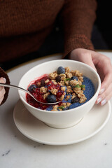 Breakfast smoothie bowl with granola on white background
