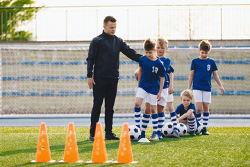 Young Coach With Kids in Soccer Team on Training Unit. Youth Team Coach Training School Boys in...