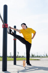 Senior woman stretching her legs outdoors on the sports ground