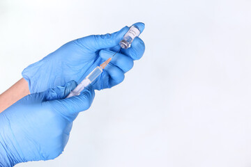  hand in blue latex gloves fill in syringe with medicine isolated on white 