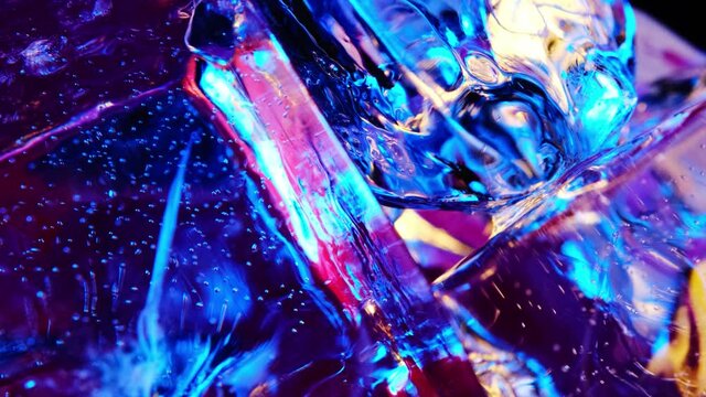 Block ice is lit with neon blue and pink in the light. rotates creating different highlights