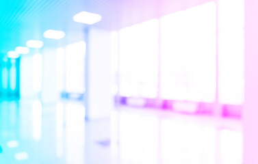 Blurred defocused bokeh background of exhibition hall or convention centre hallway. Blue and pink...