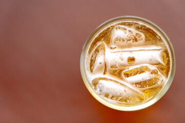 Glass of light beer on desk.