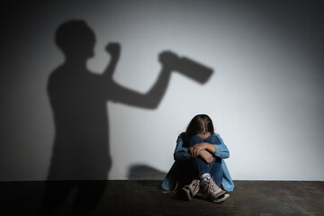 Domestic physical violence, abusing. Scared little caucasian girl, victim sitting close to white...