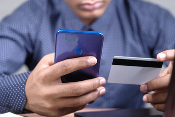 Man hand holding credit card and using smart phone shopping online 