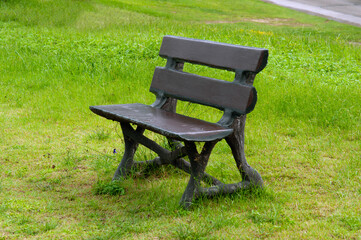 Lonely old concrete cosy bench in a public park area.