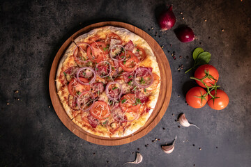Pizza with tomato onion mozzarella cheese sauce top view on wooden board gray dark background