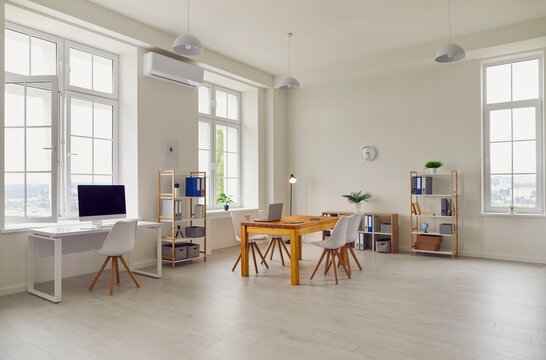 Spacious Meeting Room Of Modern Office Building With High Ceiling, Large Windows And Working Desks