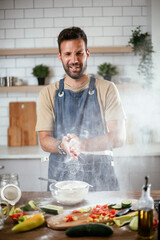 Fototapeta na wymiar Happy man baking in the kitchen. Man making fresh pasta.