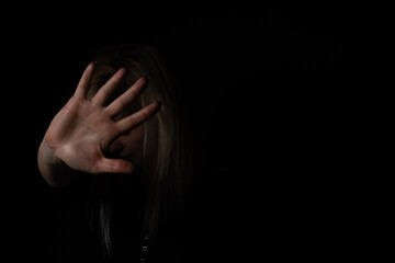 woman with raised hand on black background