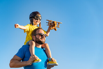 Father and son playing against blue summer sky background - 410640674