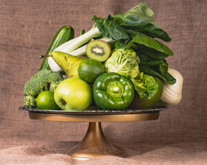 Green foods and  fruits on sackcloth background, rustic style.