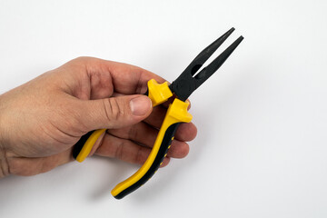 Yellow pliers in a man's hand on a white background