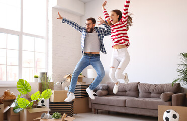 Excited couple celebrating relocation in new apartment
