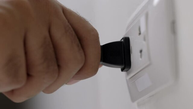 Hand remove Electric plug on socket. Electrical equipment, electrical wires and power strips in the house. Earth Hour saving electrical energy.