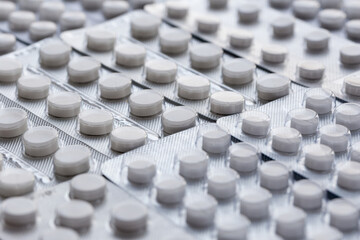 Packagings with white pills close up. Production and sale of medical preparations. Cost of the healthy life.