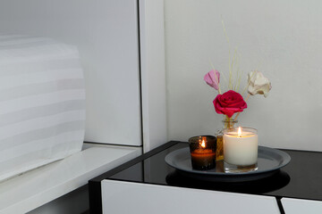 the luxury lighting aromatic scented glass candle display on bedside table to creat romanic and relax ambient in the white bedroom in the evening on valentine day
