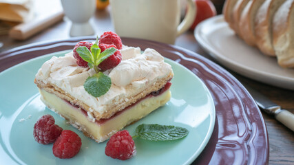 Dessert with fresh raspberries and mint on a plate. Kitchen table. Breakfast. Close-up. Soft focus in the background