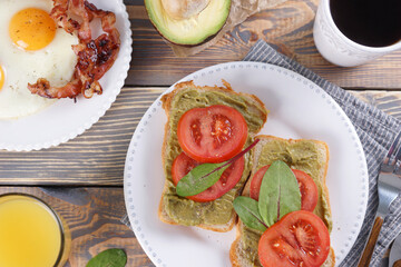 Breakfast with fried eggs with bacon and sandwiches with guacamole sauce